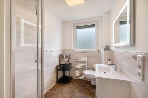 a white bathroom with a toilet and a sink at Kleines Glück in Delmenhorst