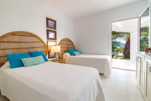a bedroom with two beds and a balcony at Casa Arola in Sant Josep de sa Talaia