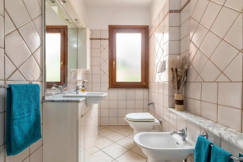 a bathroom with two sinks and a toilet at Appartamento Libio Porto Torres in Porto Torres
