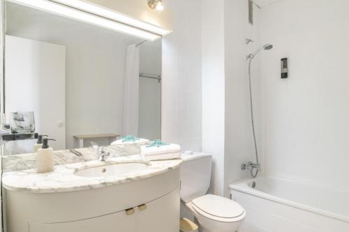a white bathroom with a sink and a toilet at Apartamento Playa Regla in Chipiona