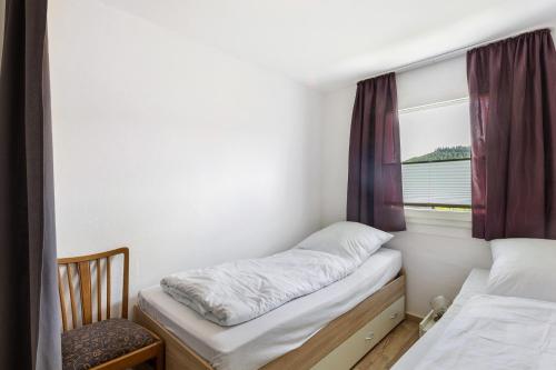 a small bedroom with a bed and a window at Ferienhaus Grobbel in Eslohe