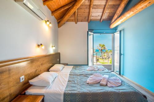a bedroom with a bed and a large window at Mirage Arillas Maisonette B in Arillas