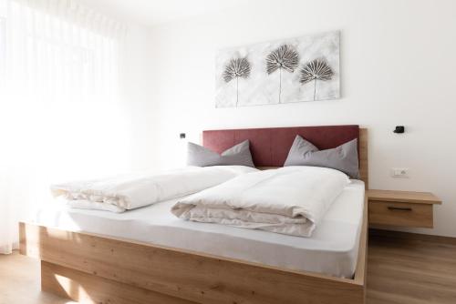 a bedroom with a large bed with white sheets at Kleon 3 in Rifiano