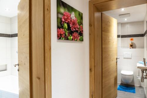 a bathroom with a toilet and a painting on the wall at Haus Alpenheim Apartment 2 in Tux