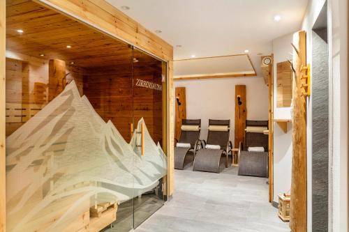a glass door leading into a room with chairs at Studio Hochzillertal mit Sauna in Ried im Zillertal