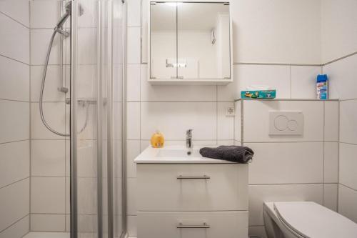 a white bathroom with a sink and a shower at Ferienwohnung Ausblick in Bremerhaven