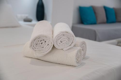 a pile of towels sitting on top of a bed at Helmos Cozy Studio in Naxos Chora
