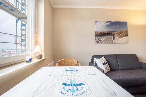 a bedroom with a bed and a couch and a window at Ferienwohnung Ausblick in Bremerhaven