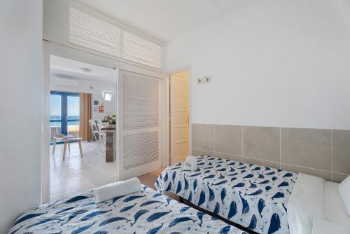 a bedroom with two beds and a view of the ocean at Apartamentos Playa Azul - 2 in Vallehermoso
