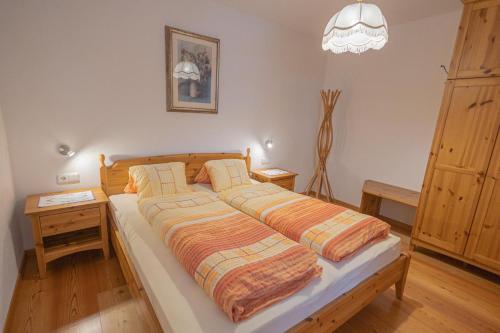 a bedroom with a large bed with two pillows at Apartment Enzian - Mesnerhof in Sand in Taufers