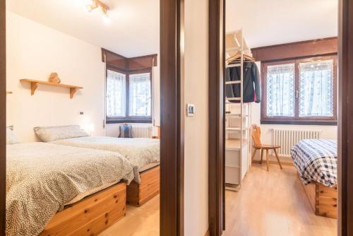 a small bedroom with two beds and a ladder at Casa Muffolina in Canazei