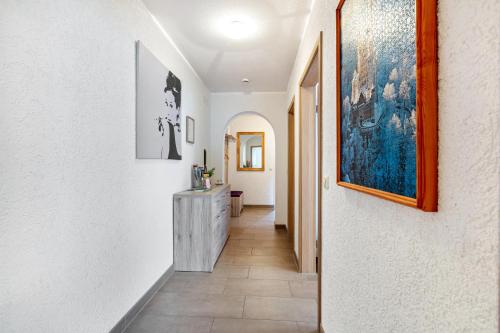 a hallway with white walls and a painting on the wall at Ferienwohnung Sägegasse, Typ A in Münstertal