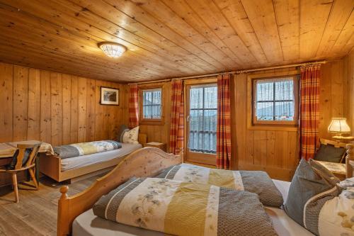 a room with three beds in a wooden cabin at Oberhof Bauernhaus in Vallarga