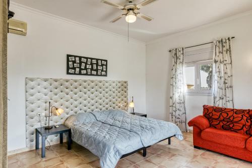 a bedroom with a bed and a red couch at Flores in Vilacolum