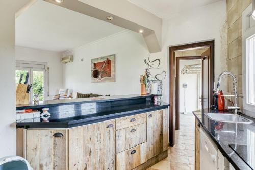 a large kitchen with wooden cabinets and a sink at Flores in Vilacolum