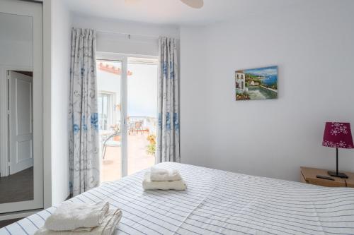 a bedroom with a white bed with two towels on it at Casa Sydhavshytten in Nerja