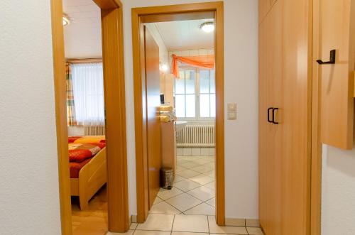 a hallway with a door to a room with a bed at Heizmannshof in Hofstetten