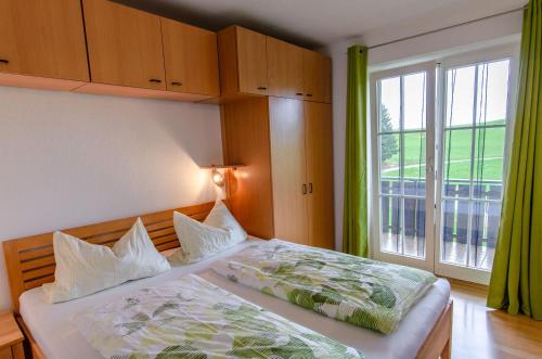 a bedroom with a bed and a large window at Heizmannshof in Hofstetten