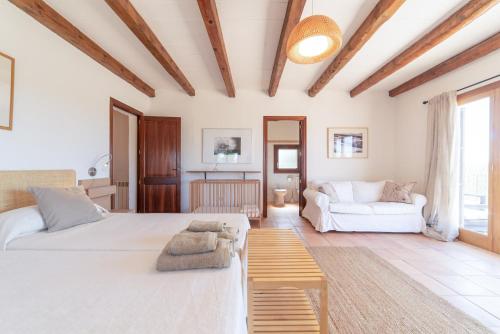 a bedroom with a large bed and a couch at S'hort des Frares in El Palmer