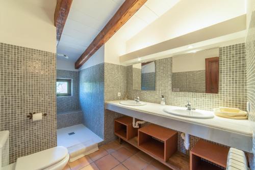 a bathroom with two sinks and a toilet at S'hort des Frares in El Palmer
