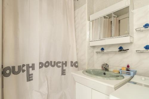 a bathroom with a sink and a shower curtain at Aux Pins Maritimes - A22 in Pornic