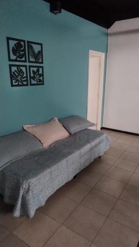 a bed in a room with a blue wall at Alojamiento El Centenario in San Martín