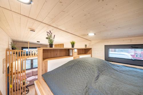 a bedroom in a tiny house with a large bed at Tiny House Ingo John 'Vanessa' in Sandstedt