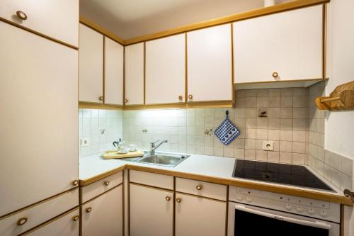a kitchen with white cabinets and a sink at Manuel's App Watschinger - Frieda in Sesto