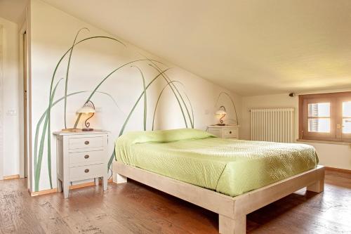 a bedroom with a green bed and two night stands at Villa delle Palme in Cecina