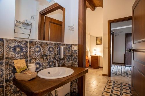 a bathroom with a sink and a mirror at Arcaloro Resort in SantʼAngelo di Brolo