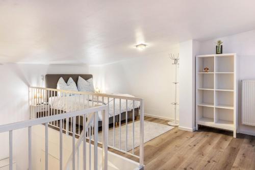 a white bedroom with a crib in a room at Nahe Airport Ber Maisonettewohnung in Schönefeld