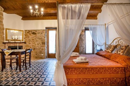 a bedroom with a bed and a table in a room at Arcaloro Resort in SantʼAngelo di Brolo