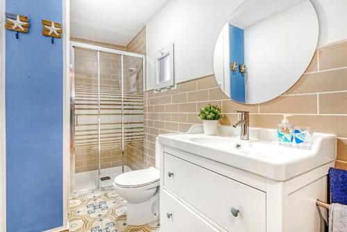 a bathroom with a sink and a toilet and a mirror at Villa Mediterraneo in Oliva