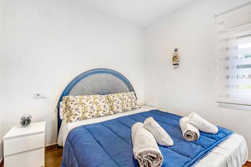 a bedroom with a blue bed with towels on it at Villa Mediterraneo in Oliva