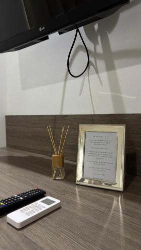 a remote control and a picture on a desk at Lindo Flat Completo 311 in Nova Iguaçu