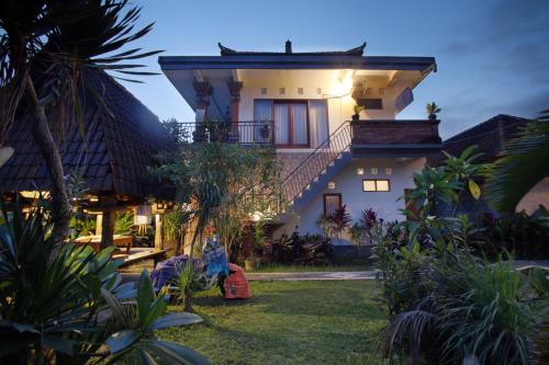ein Haus mit einer Treppe in einem Garten in der Nacht in der Unterkunft Loris Homestay in Ubud