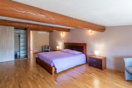 a bedroom with a bed and a chair in it at Villa du soleil levant in Apt