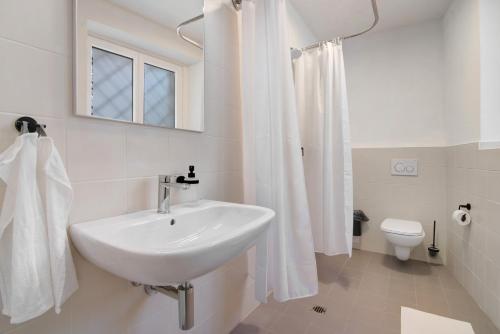a white bathroom with a sink and a toilet at Workation Castle in Carlazzo