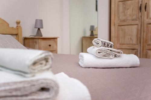 a pile of towels sitting on top of a bed at Casa delle Mimose in Orosei