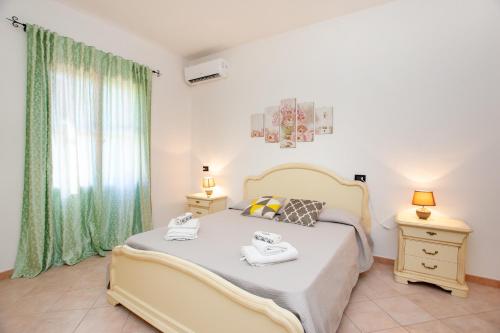 a bedroom with a large bed and a window at Casa delle Mimose in Orosei
