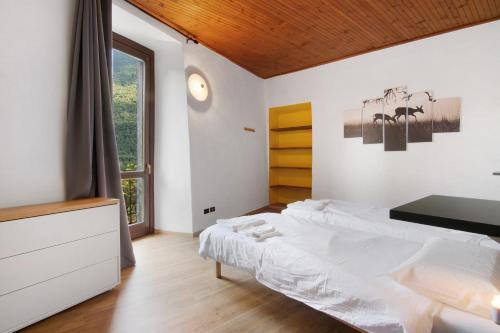 a white bedroom with a bed and a window at Workation Castle in Carlazzo