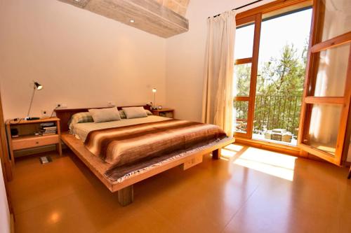 a bedroom with a bed and a large window at Sa Portassa in Felanitx