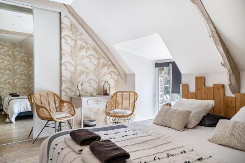 a bedroom with a large bed and two chairs at Gîte Les Hervelines in Pleudihen-sur-Rance