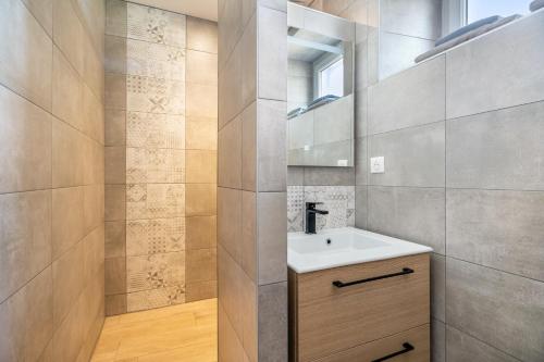 a bathroom with a sink and a mirror at Gîte Les Hervelines in Pleudihen-sur-Rance