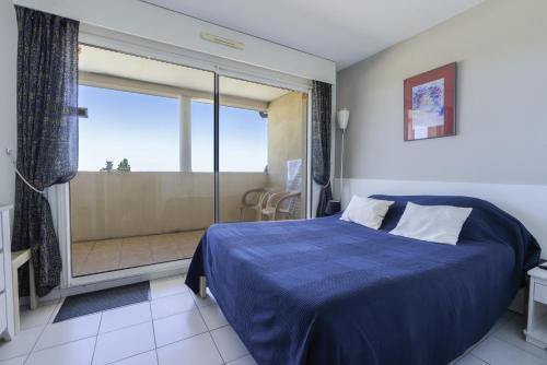 a bedroom with a bed and a sliding glass door at Appartement clim piscine garage in Le Grau-du-Roi