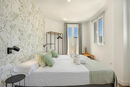 a white bedroom with a large bed with a window at Casa Milano 3 in Jerez de la Frontera