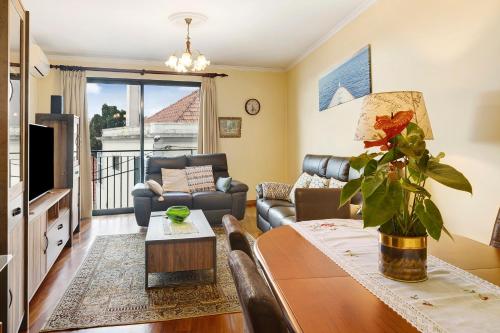 a living room with a couch and a table at Palheiro Residence Vista Mar in Funchal