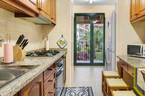 a kitchen with a sink and a stove at Palheiro Residence Vista Mar in Funchal