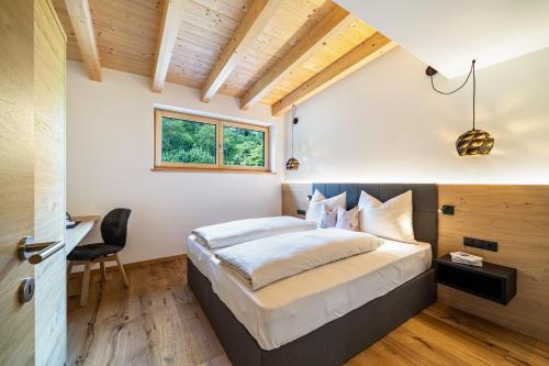 a bedroom with a bed and a desk and a window at Wiesgut Ferienwohnung Golden in Tesimo
