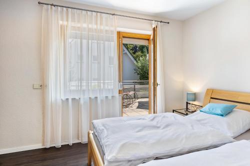 a bedroom with two beds and a sliding glass door at Haus Regina in Löffingen